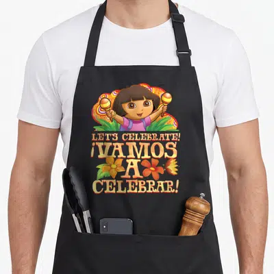 Celebrate explorer apron - Cartoon girl holding maracas with bilingual celebrate text and colorful flowers — shown on a black cotton canvas apron against a white background