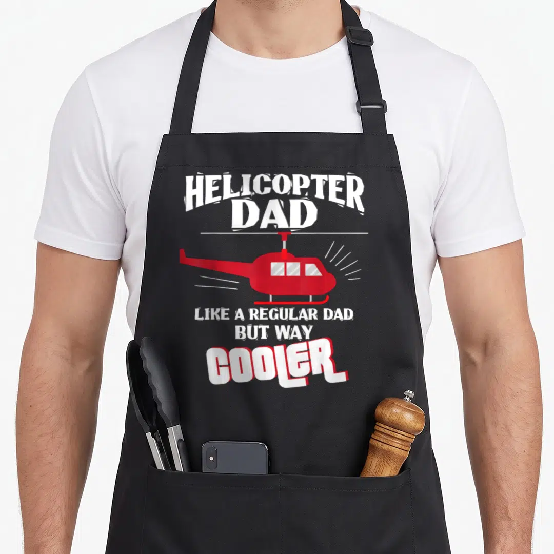 Helicopter father day apron - Red helicopter graphic with white text reading Helicopter Dad Like A Regular Dad But Way — shown on a black cotton canvas apron against a white background
