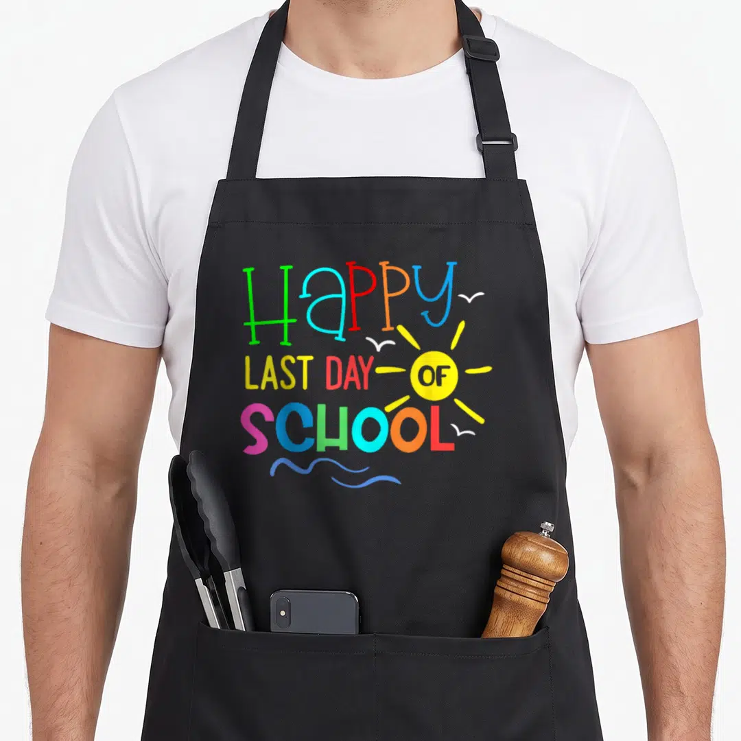 Break teacher apron - Stacked colorful text Happy Last Day Of School with yellow sun and blue waves — shown on a black cotton canvas apron against a white background