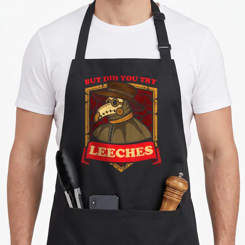 But doctor apron - Plague doctor in yellow frame with red banner reading But Did You Try Leeches — shown on a black cotton canvas apron against a white background