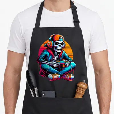 Video gaming halloween apron - Cartoon skeleton in streetwear holding controller against orange circle — shown on a black cotton canvas apron against a white background