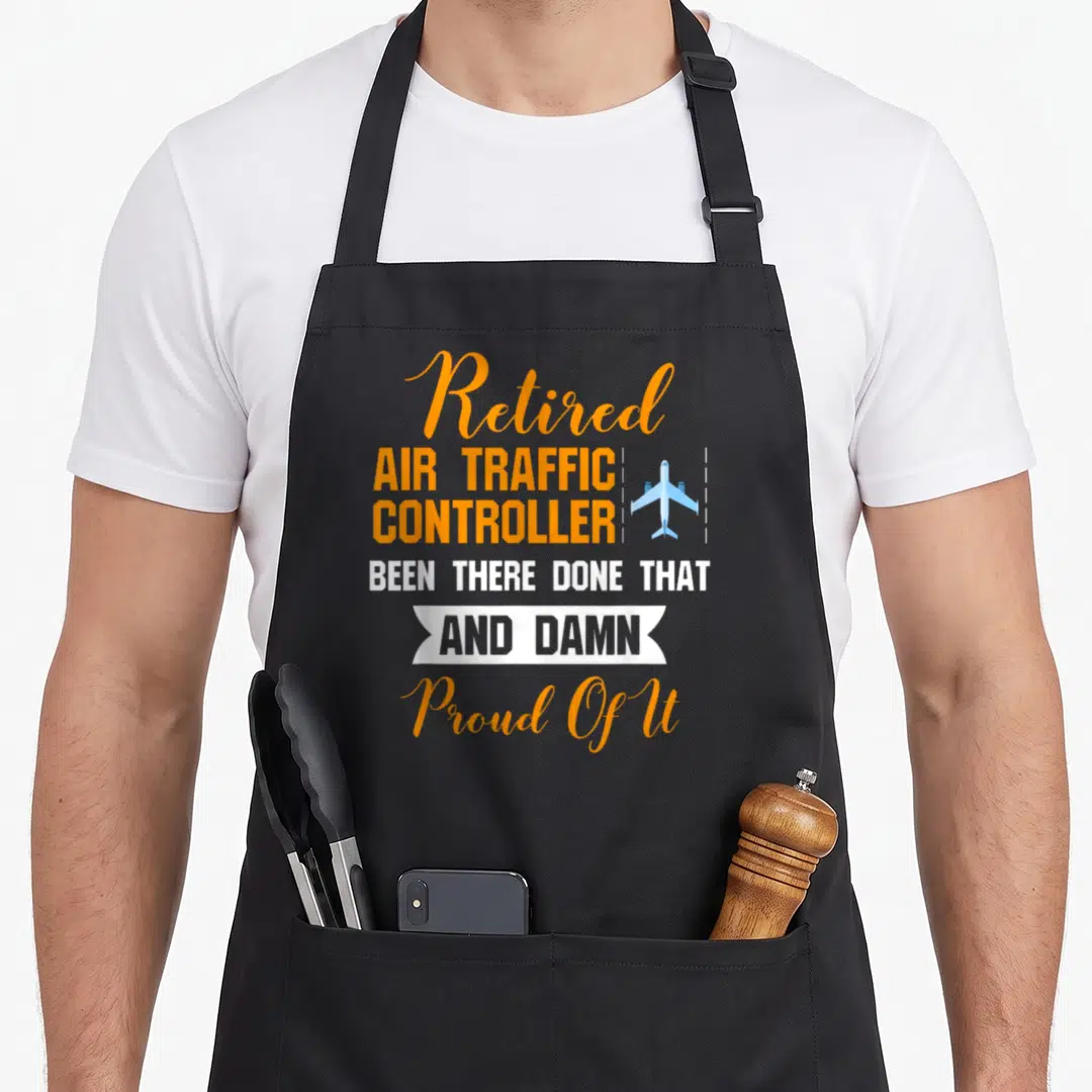 Proud air traffic controller apron - Stacked orange and white text reading Retired Air Traffic Controller with blue — shown on a black cotton canvas apron against a white background