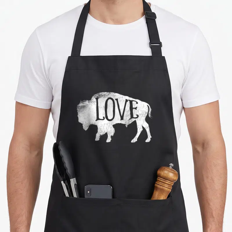 Silhouette buffalo apron - Distressed white bison silhouette with the word love printed inside the body — shown on a black cotton canvas apron against a white background