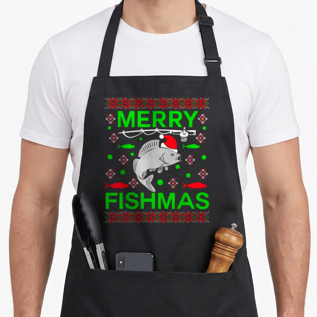 Fishmas merry christmas apron - Cartoon fish in Santa hat under fishing rod with green and red dots and MERRY FISHMAS — shown on a black cotton canvas apron against a white background