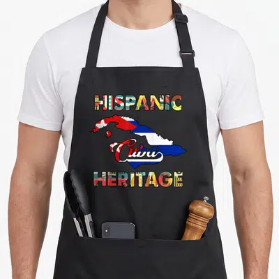 Cuba heritage hispanic aprons - Map of Cuba with red blue white yellow green flag fill and HISPANIC HERITAGE text — shown on a black cotton canvas apron against a white background