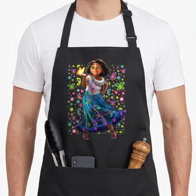 Maribel magic apron - Mirabel Madrigal holding a butterfly surrounded by scattered colorful butterflies and flowers — shown on a black cotton canvas apron against a white background