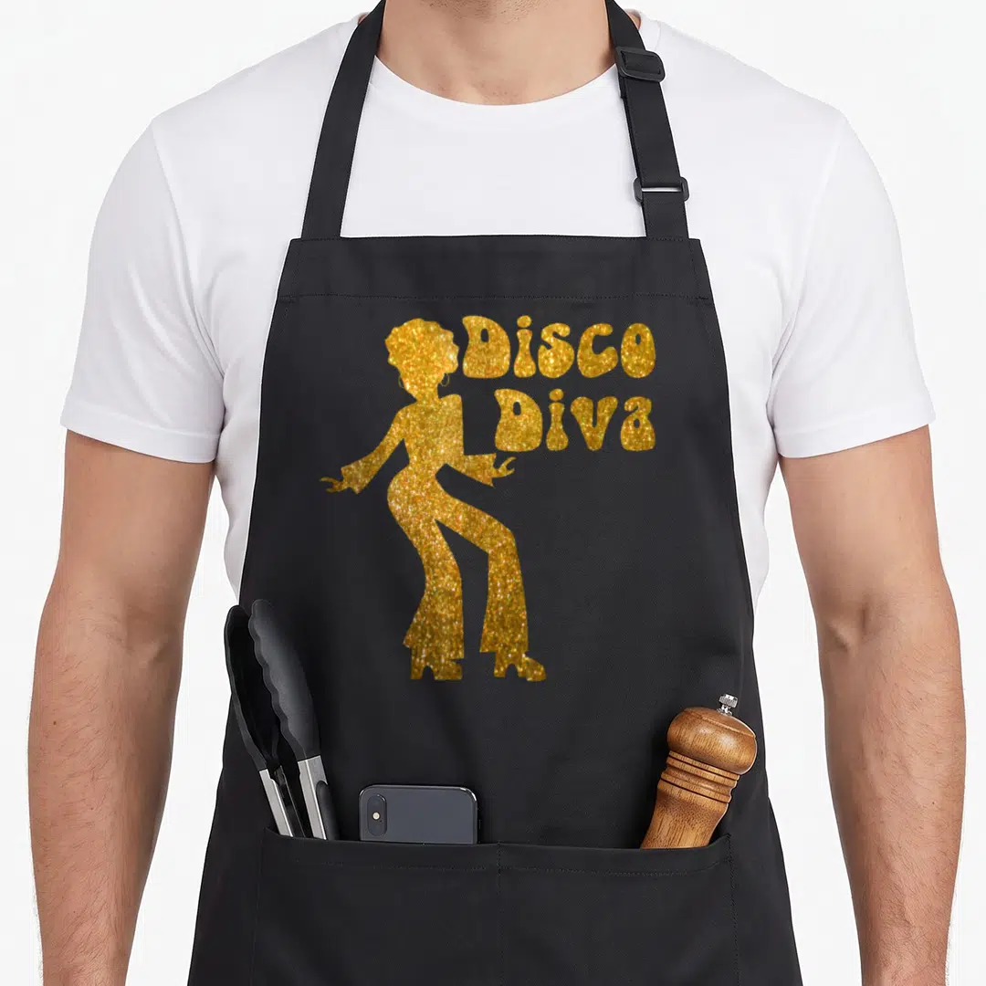 Diva 70s apron - Gold glitter silhouette of a dancing woman beside stacked Disco Diva text — shown on a black cotton canvas apron against a white background