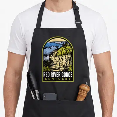 River chimney apron - Retro arched print of beige rock formation and green trees with Red River Gorge Kentucky text — shown on a black cotton canvas apron against a white background