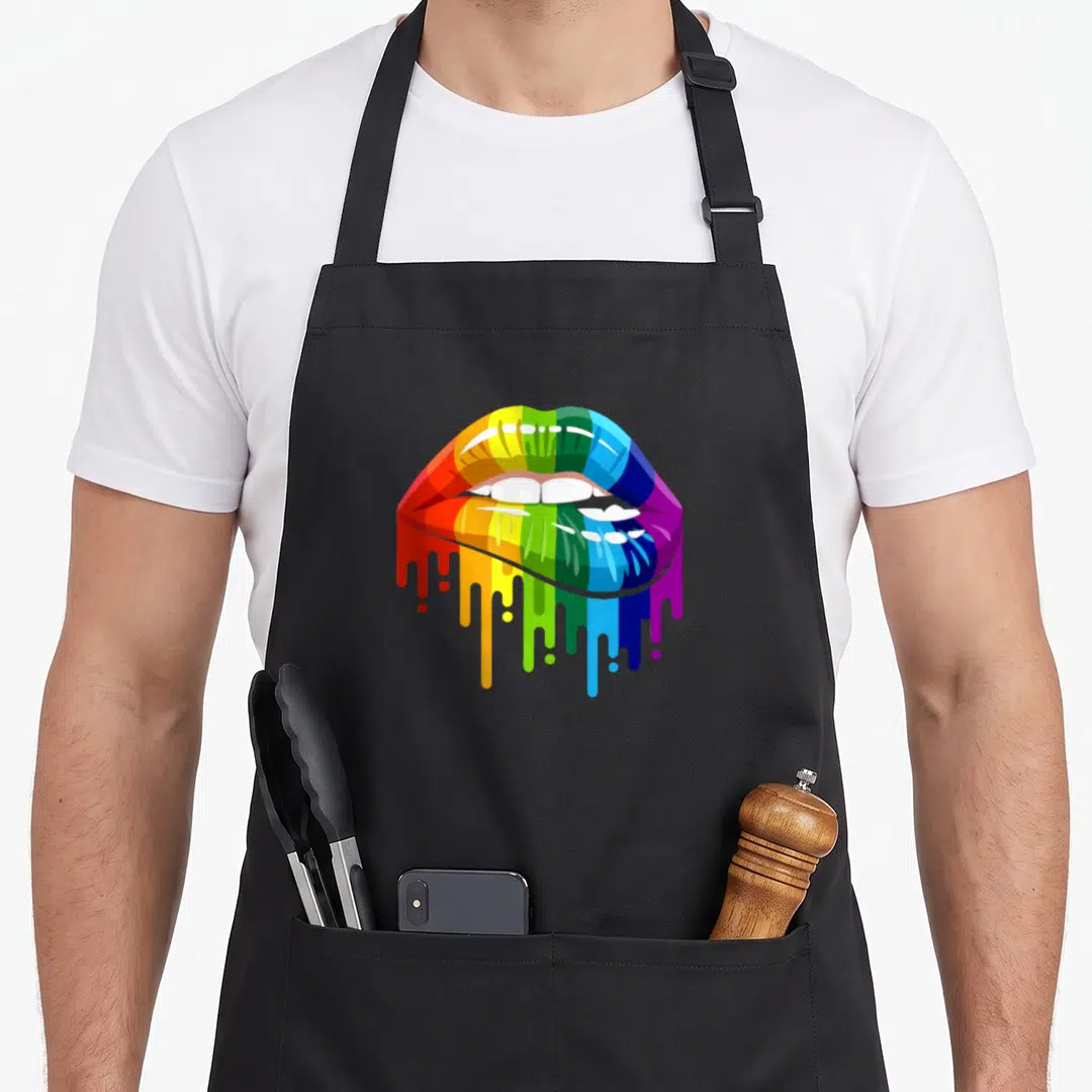 Lgbtq rainbow apron - Rainbow colored lips with dripping paint in red orange yellow green blue purple cartoon style — shown on a black cotton canvas apron against a white background