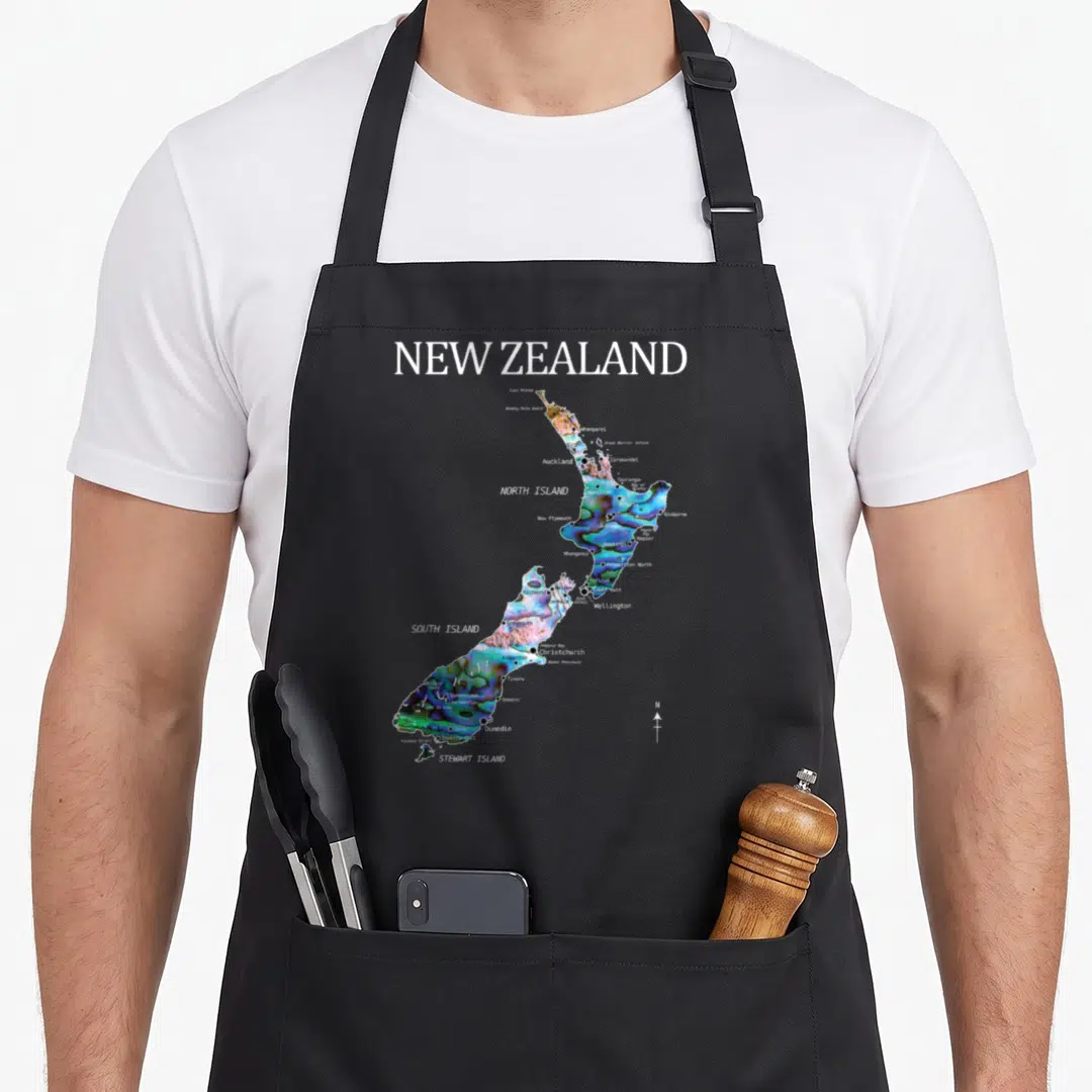 Kiwi new zealand apron - Multicolored map of New Zealand with city labels and compass needle printed on canvas — shown on a black cotton canvas apron against a white background
