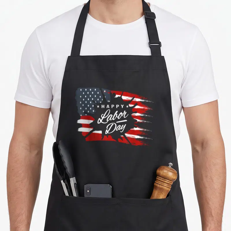 Labor american flag apron - Distressed USA flag with HAPPY Labor Day text and two stars — shown on a black cotton canvas apron against a white background