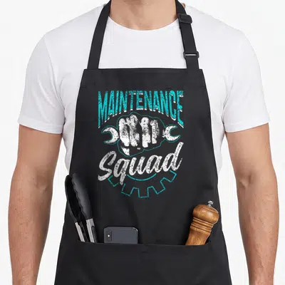 Maintenance janitorial apron - Cyan and white distressed fist with wrenches and gear text — shown on a black cotton canvas apron against a white background
