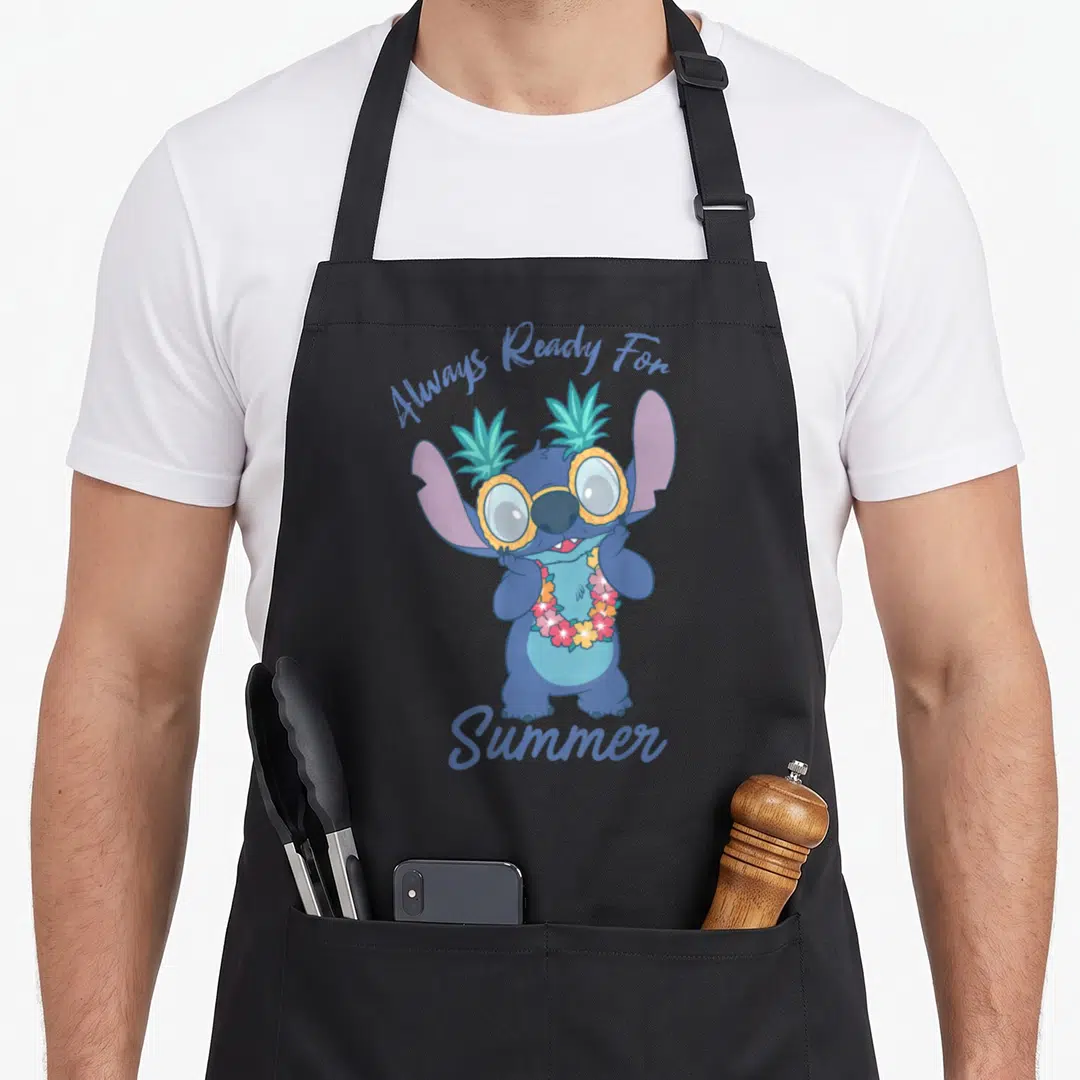 Glass quirky apron - Stitch character wearing pineapple glasses and floral lei with arched text Always Ready For Summer — shown on a black cotton canvas apron against a white background