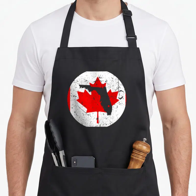 Floridian pride apron - Grey Florida map over red maple leaf in distressed white circle with red bands — shown on a black cotton canvas apron against a white background