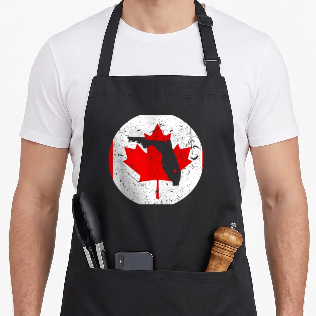 Floridian pride apron - Grey Florida map over red maple leaf in distressed white circle with red bands — shown on a black cotton canvas apron against a white background