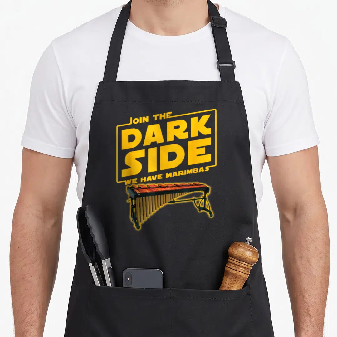 Join marimba apron - Yellow text box reading Join The Dark Side We Have Marimbas above a marimba instrument — shown on a black cotton canvas apron against a white background