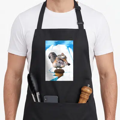 Age old ice apron - Cartoon saber-toothed squirrel on acorn with cracked iceberg background — shown on a black cotton canvas apron against a white background
