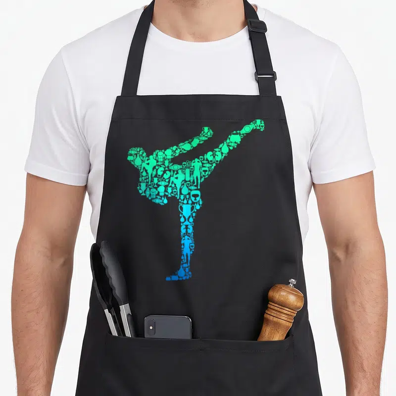 Kickboxing taekwondo apron - Martial artist silhouette formed by trophies and boxing gear in green and blue gradient — shown on a black cotton canvas apron against a white background