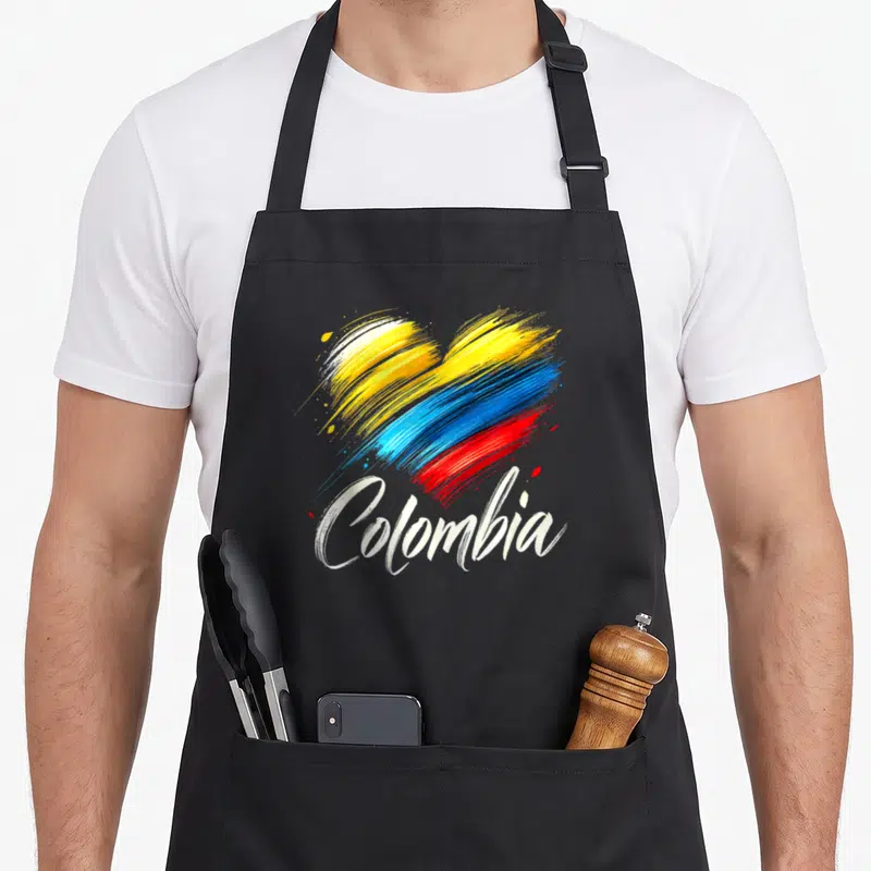 Colombian pride apron - Heart of yellow blue red and white brushstrokes with Colombia script below — shown on a black cotton canvas apron against a white background