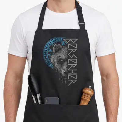 Berserker viking apron - Grey bear head line art with blue runic circle border on grey background — shown on a black cotton canvas apron against a white background