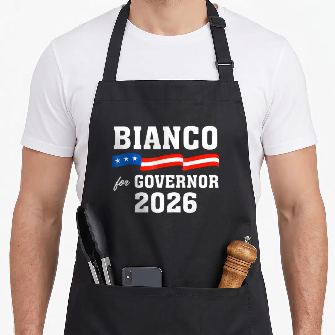Bianco chad apron - BIANCO for GOVERNOR 2026 text with waving patriotic ribbon containing three white stars — shown on a black cotton canvas apron against a white background