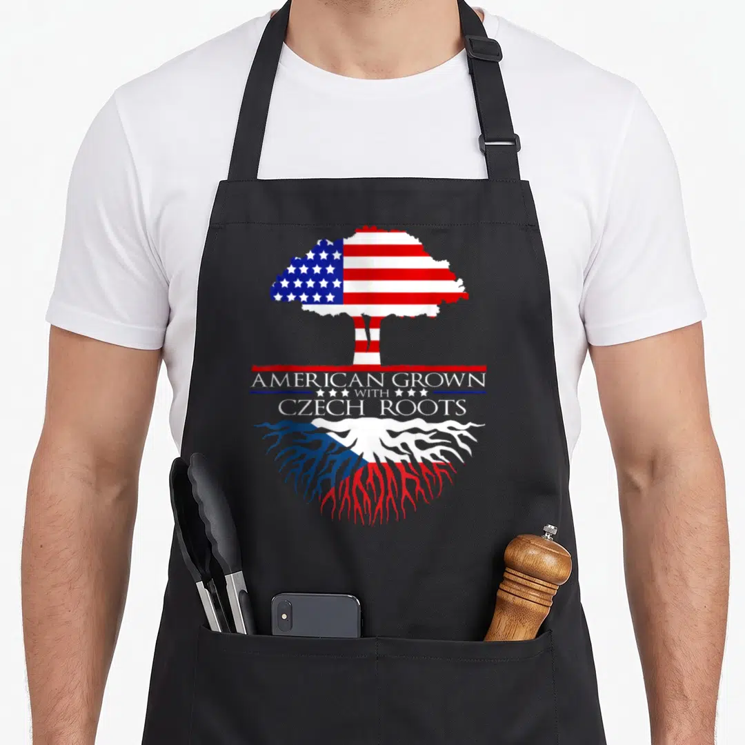 Ingenius american flag apron - Tree with US flag canopy and Czech flag roots above stacked text AMERICAN GROWN — shown on a black cotton canvas apron against a white background