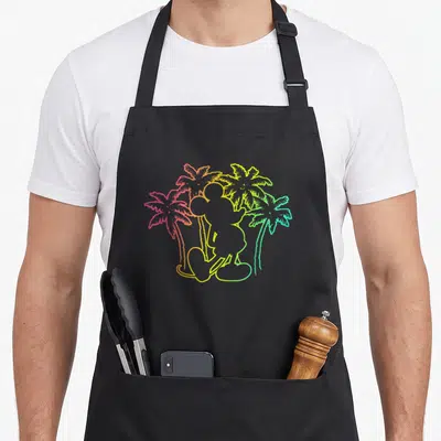 Silhouette tree apron - Colorful Mickey Mouse silhouette with four rainbow palm trees — shown on a black cotton canvas apron against a white background
