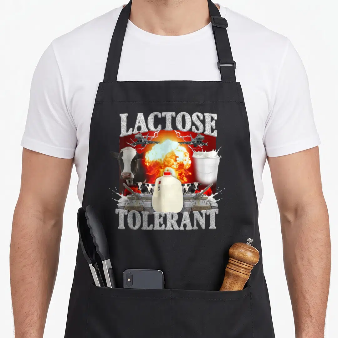 Lactose novelty apron - Milk jug surrounded by tanks jets and explosion with lactose tolerant text — shown on a black cotton canvas apron against a white background