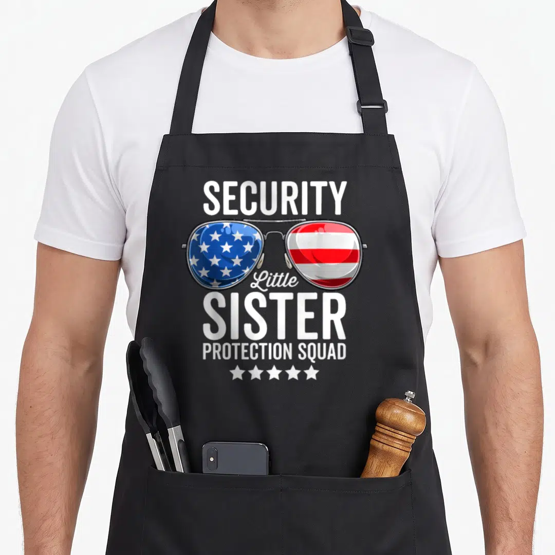 Protection brother sister squad apron - Sunglasses with US flag lenses and text Security Little Sister Protection Squad — shown on a black cotton canvas apron against a white background