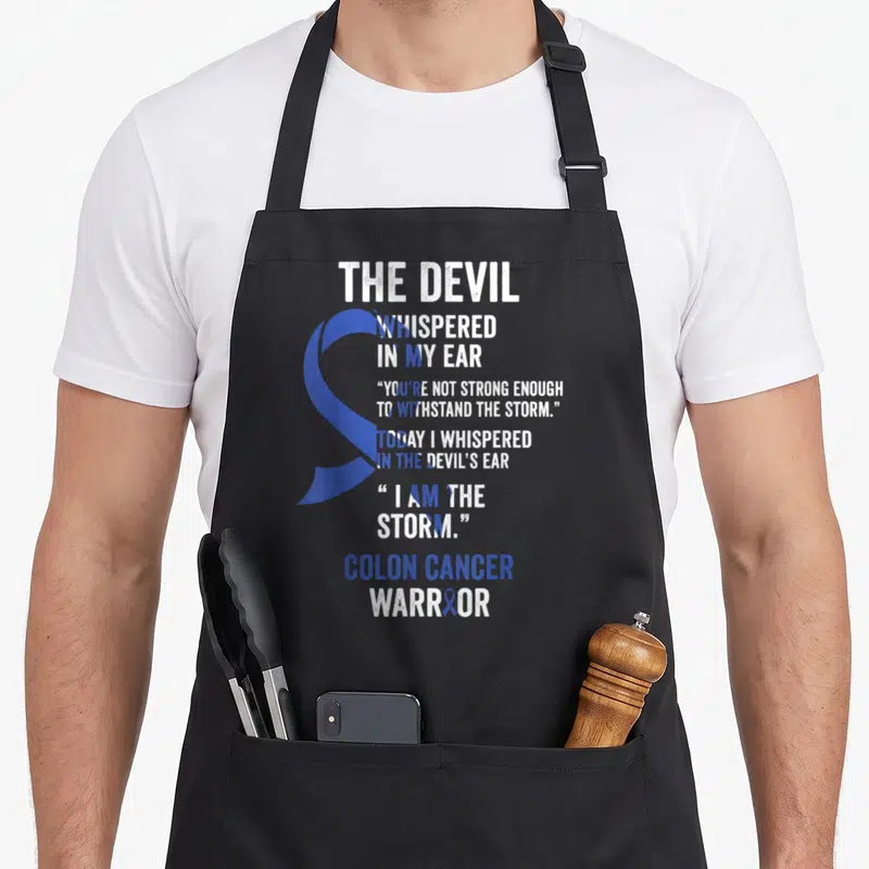 Colon devil's apron - The Devil Whispered In My Ear blue ribbon Colon Cancer Warrior typography design — shown on a black cotton canvas apron against a white background