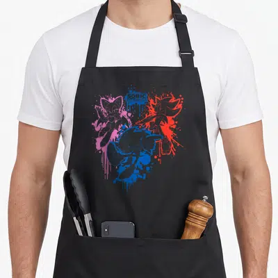 Rouge paint apron - Sonic, Shadow, and Rouge characters over blue, pink, and red paint splatters with title text — shown on a black cotton canvas apron against a white background