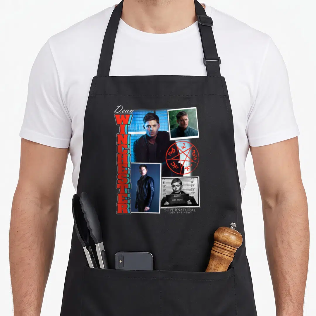 Ripple theme aprons - Dean Winchester photo collage with red pentagram and vertical WINCHESTER lettering — shown on a black cotton canvas apron against a white background