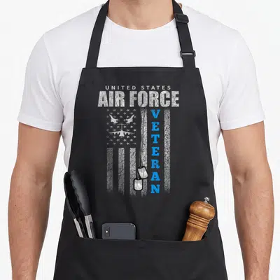 Force us aprons - Distressed USA flag with three planes, vertical VETERAN text, and hanging dog tags in white blue grey — shown on a black cotton canvas apron against a white background