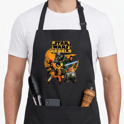 Rebel fan fiction apron - Star Wars Rebels logo over orange crescent with four characters in yellow orange blue cartoon — shown on a black cotton canvas apron against a white background
