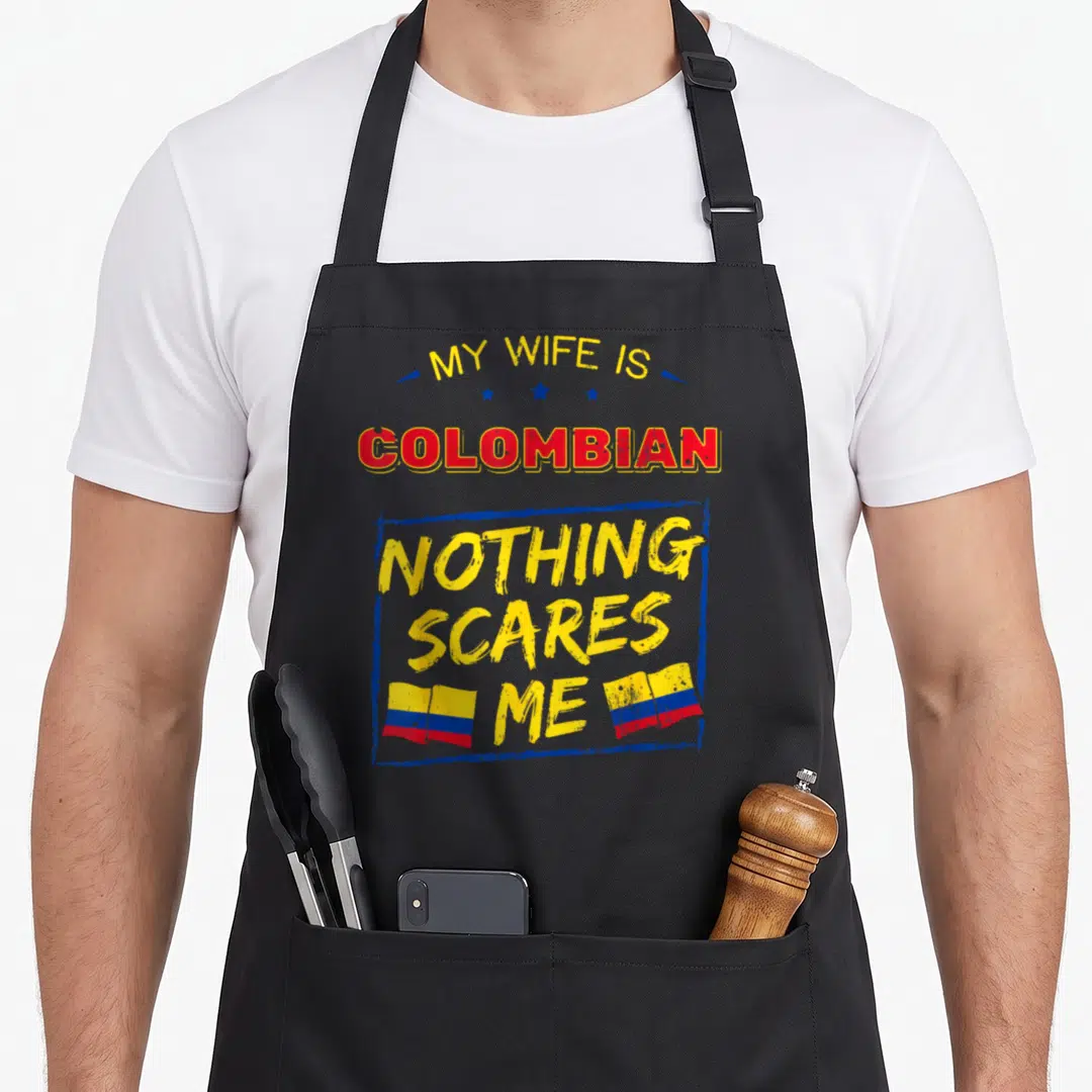 Colombian wife apron - Stacked yellow and red text reading My Wife Is Colombian Nothing Scares Me with two flags — shown on a black cotton canvas apron against a white background