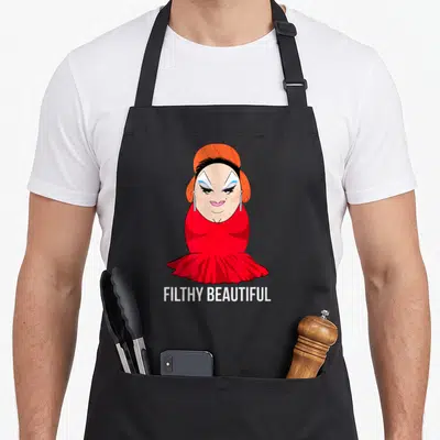 Divine beautiful apron - Cartoon woman in red dress and orange hair above white text reading FILTHY BEAUTIFUL — shown on a black cotton canvas apron against a white background