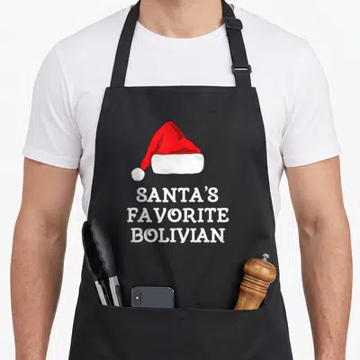 Bolivian christmas apron - Red and white Santa hat above three lines of white text reading Santa's Favorite Bolivian — shown on a black cotton canvas apron against a white background