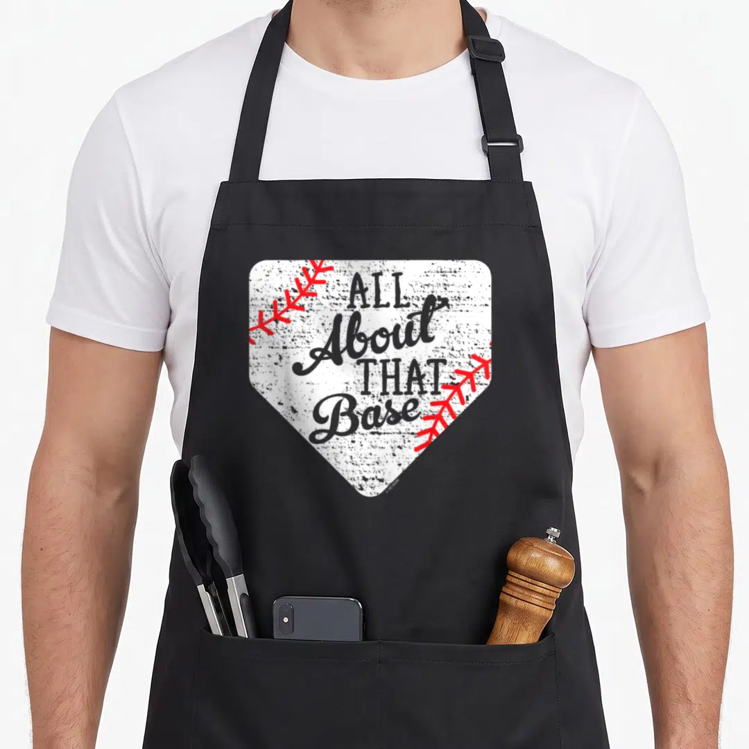 Base baseball apron - White home plate with grey text All About That Base and red stitching accents — shown on a black cotton canvas apron against a white background