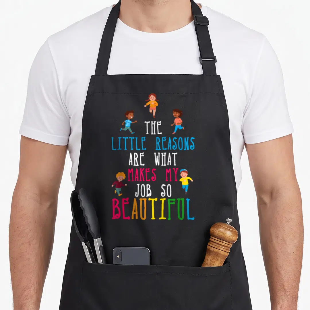 Reason daycare teacher aprons - Stacked text The Little Reasons Makes My Job So Beautiful surrounded by four running — shown on a black cotton canvas apron against a white background