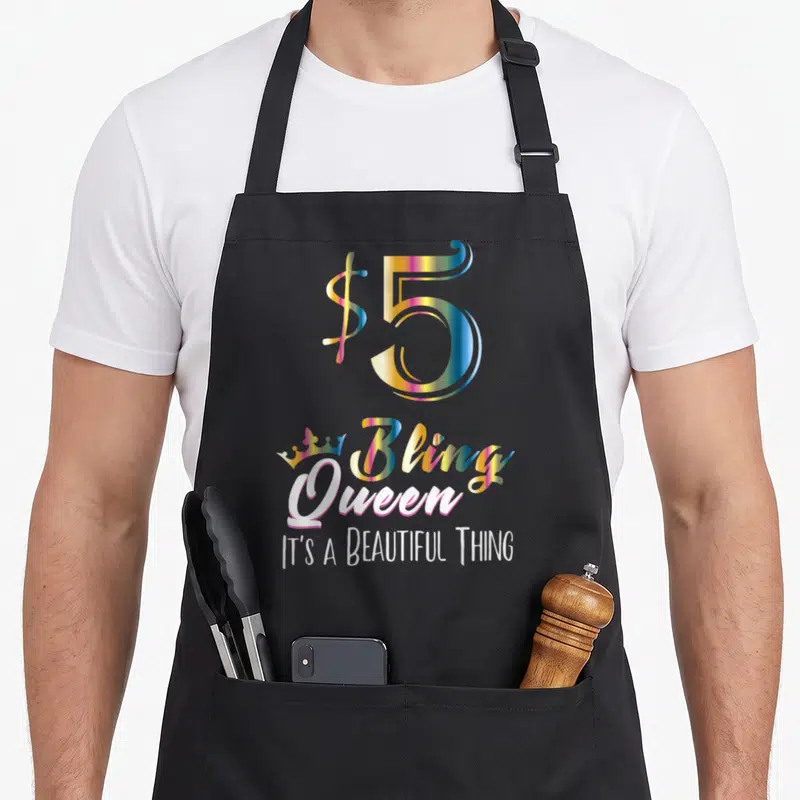 Bling queen apron - Stacked text $5 Bling Queen IT'S A BEAUTIFUL THING in iridescent and white fonts — shown on a black cotton canvas apron against a white background