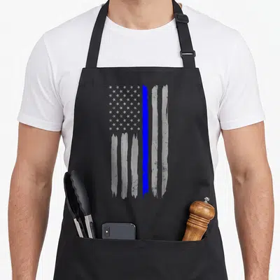 Support police apron - Distressed grey flag with vertical blue brush stroke stripe and white stars — shown on a black cotton canvas apron against a white background