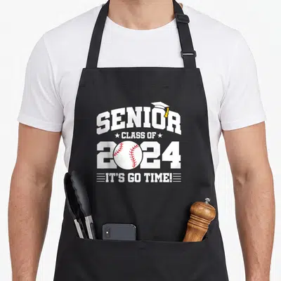 Senior baseball apron - White SENIOR text with graduation cap, baseball replacing zero, and It's Go Time slogan in red — shown on a black cotton canvas apron against a white background