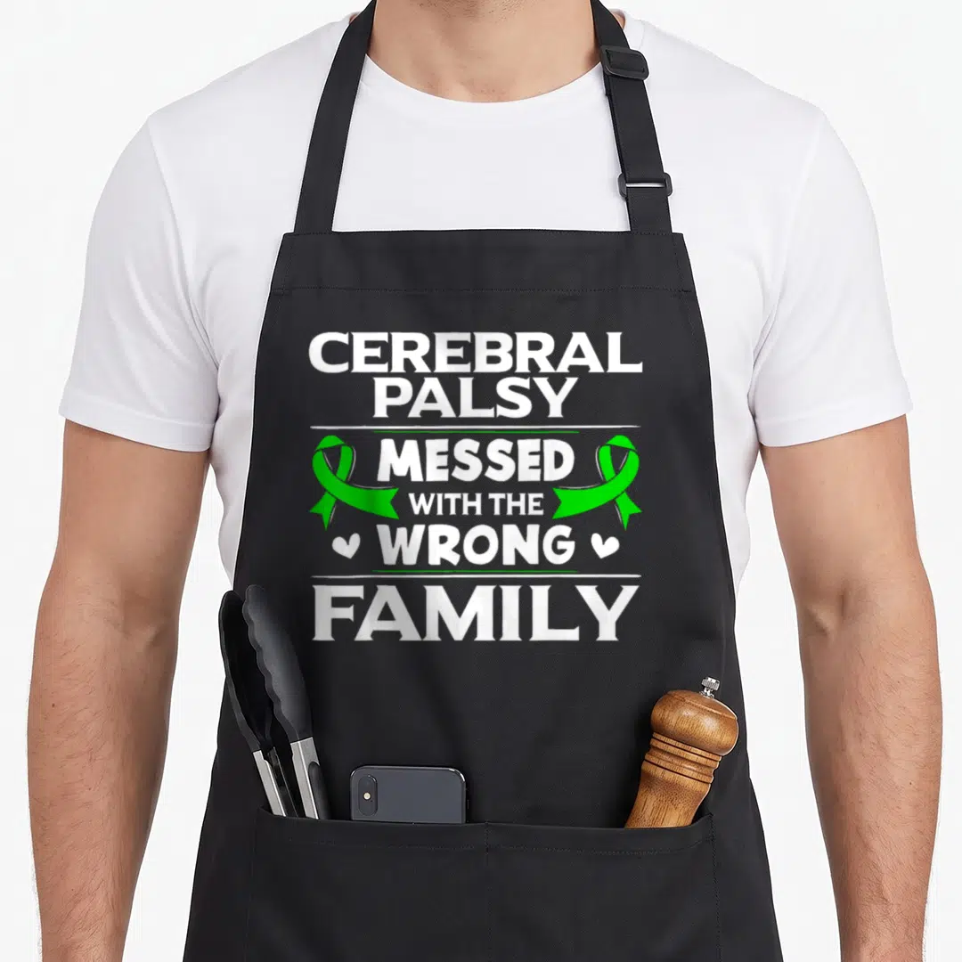 Damage cerebral palsy awareness apron - Stacked white text CEREBRAL PALSY MESSED WITH THE WRONG FAMILY flanked by two — shown on a black cotton canvas apron against a white background
