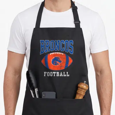 Football broncos apron - Distressed blue BRONCOS text over orange football with horse logo and white FOOTBALL text — shown on a black cotton canvas apron against a white background
