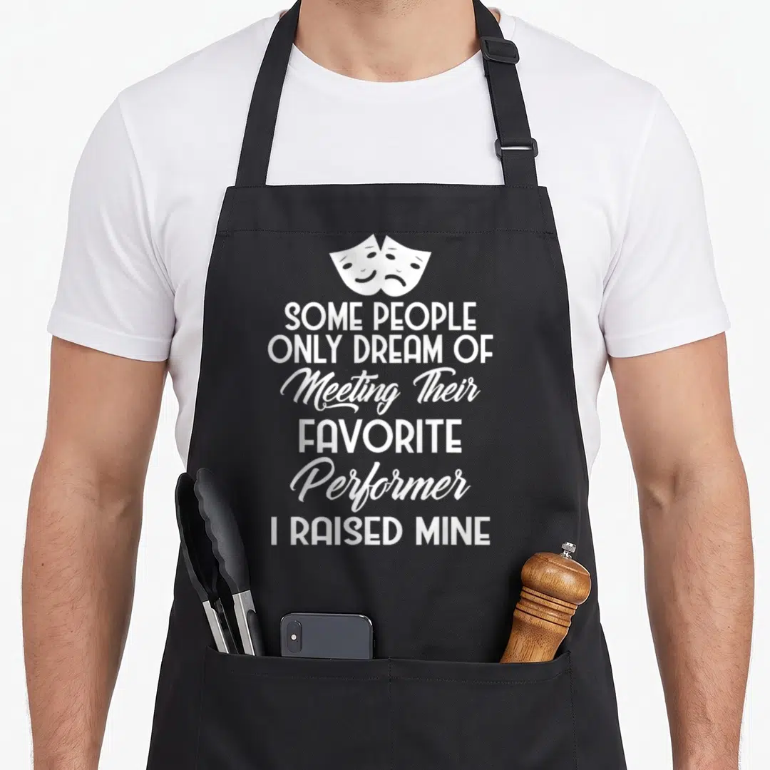 Parent people meet apron - Two white drama masks above stacked text reading Some People Only Dream of Meeting — shown on a black cotton canvas apron against a white background