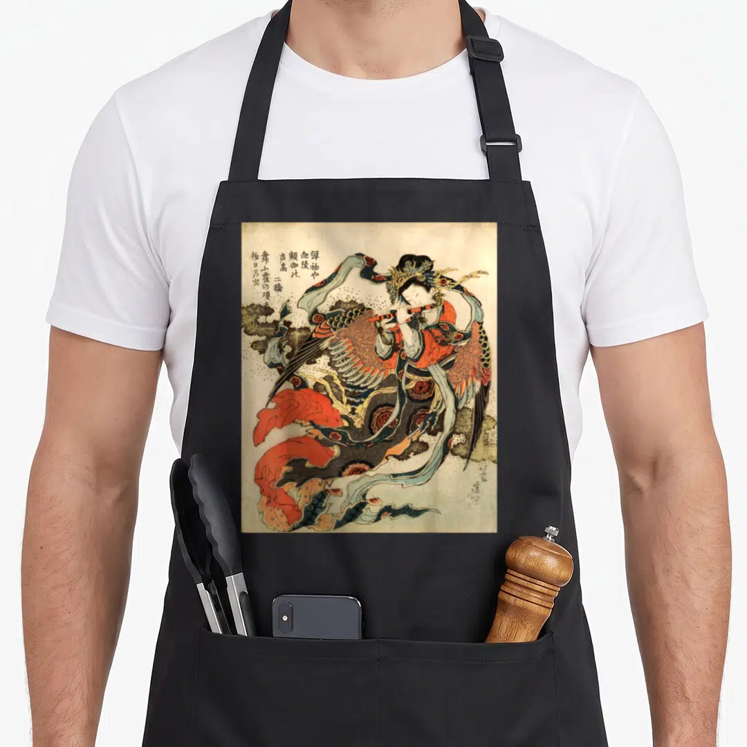 Japanese flute apron - Winged woman playing flute with kanji and clouds in red gold black beige — shown on a black cotton canvas apron against a white background