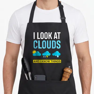 Cloud i love meteor apron - I look at clouds text with three weather icons in white blue and yellow — shown on a black cotton canvas apron against a white background
