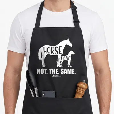 Horse dane dog apron - White horse and dog silhouettes with internal text HORSE DANE and bottom phrase NOT THE SAME — shown on a black cotton canvas apron against a white background