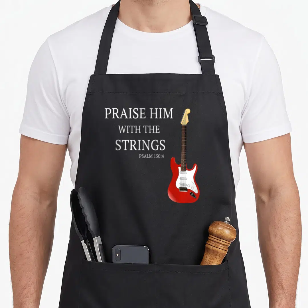 Praise string guitar christian apron - Red electric guitar with white pickguard beside stacked white text PRAISE HIM — shown on a black cotton canvas apron against a white background