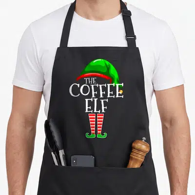 Coffee personalized family aprons - The Coffee Elf text forming a body with green hat and red striped legs — shown on a black cotton canvas apron against a white background